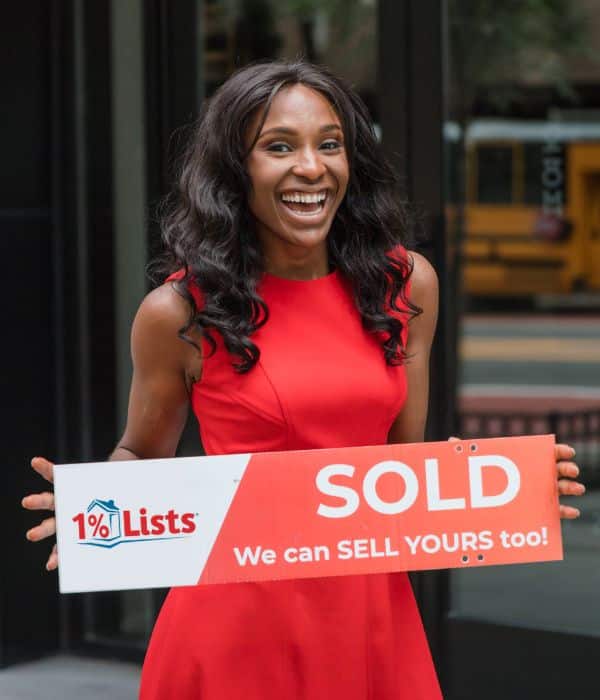 Client holding a 1 Percent Lists sold sign