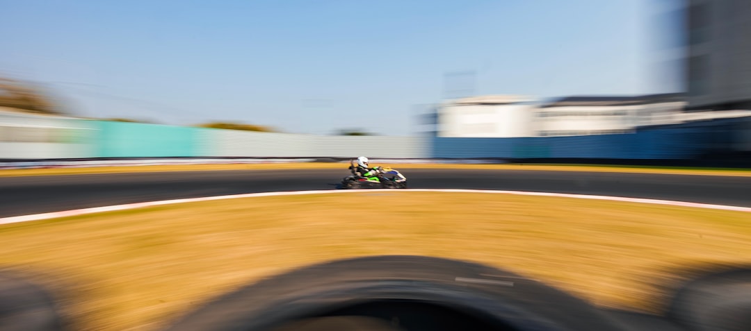 Dynamic shot of a checkered flag waving victoriously as a blurred race car speeds past the finish line, symbolizing a win.