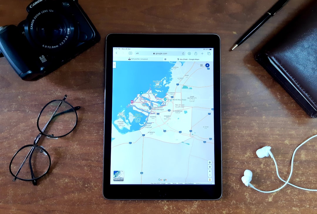 A person's hands holding a tablet computer that displays a 3D virtual tour of a modern living room, representing a tech-forward real estate model.