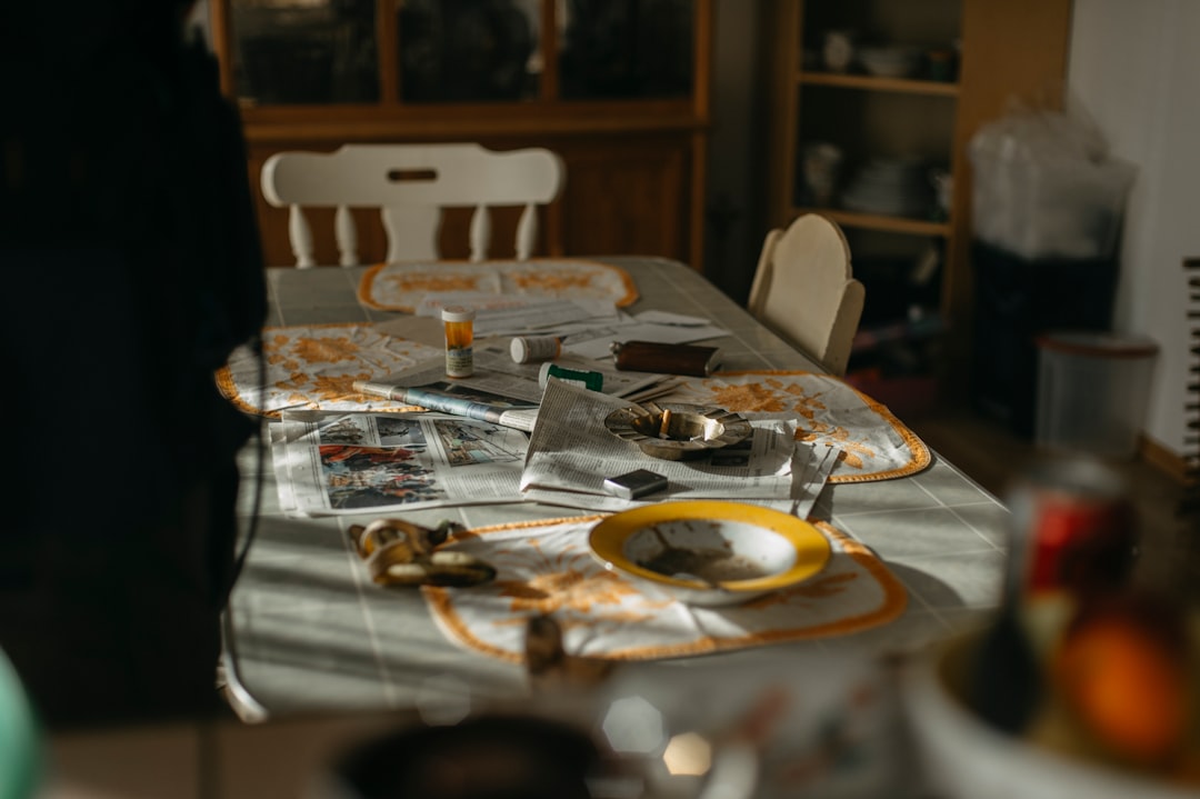 Homeowner sits at their kitchen table with a calculator and financial documents, looking concerned about real estate expen...