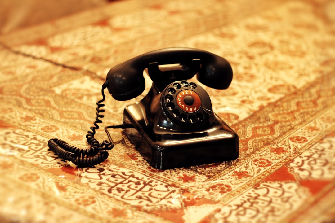 Vintage wooden office desk with an old black rotary telephone and a typewriter, symbolizing outdated business methods from...
