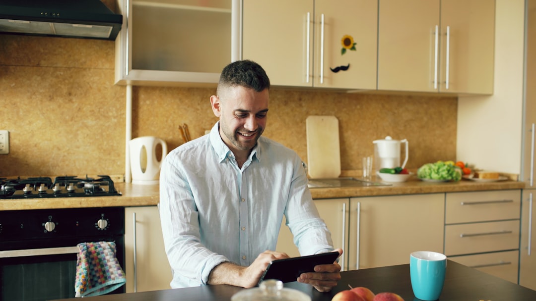 A professional real estate agent stands in a bright, modern living room, using a tablet to showcase a listing, representing a tech-forward and efficient sales process.