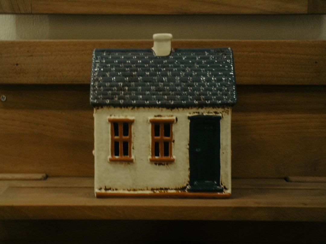 A minimalist photo of a house-shaped piggy bank next to a set of keys, symbolizing the financial savings from a lower real estate commission.