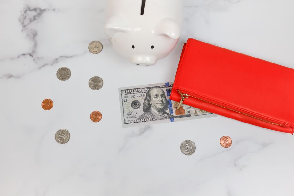 A clean, modern piggy bank sitting on a wooden table inside a bright and stylish home, representing saving money on real estate commissions.