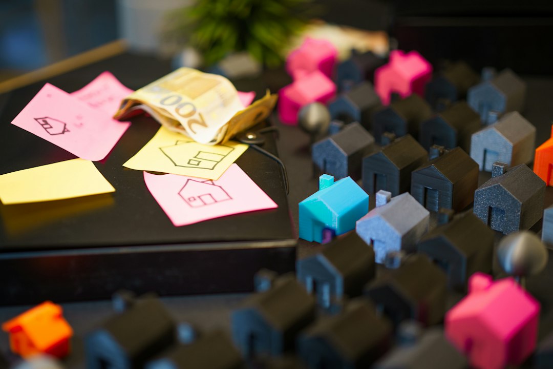 A close-up shot of a miniature house model sitting next to a neatly stacked pile of coins, representing the growth and protection of home equity.