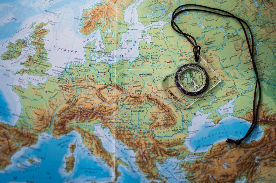 A compass and a house key lying on a map, symbolizing expert navigation through a shifting real estate market.