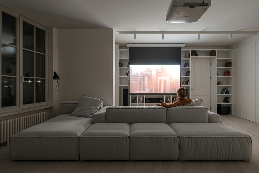 A real estate professional reviews data on a tablet while standing in a bright, modern living room, illustrating a tech-savvy, data-driven marketing strategy.
